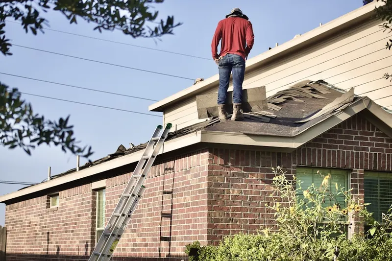 Professional roofer working on a residential roof in Oshtemo